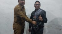 Kepala Biro Pengadaan Barang dan Jasa Setda Provinsi Sumut, Mulyono ST MSi mengalungkan syal (ulos) kepada Ketua PWI Sumsel, H Firdaus Komar Spd MSi, Senin (6/2/2023) malam